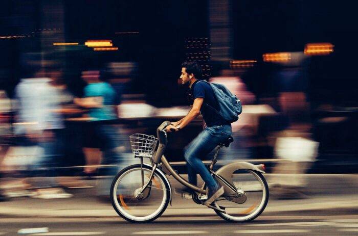 man riding bicycle on city street 310983 scaled