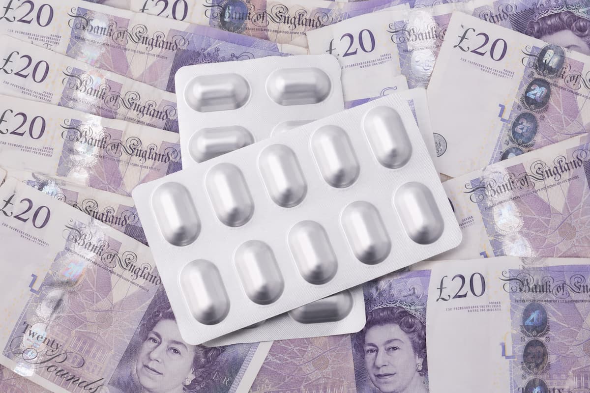 Packets of tablets resting on twenty pound notes, representing the cost to employers of the 2026 statutory sick pay changes